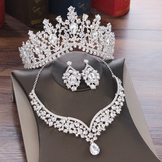 Sparkling silver-tone necklace and matching earrings set with clear round and teardrop rhinestones on a black display. - Image 6
