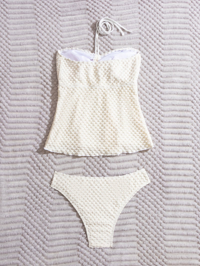 Off-white textured two-piece women's swimsuit with a bandeau halter top and high-cut bottoms, displayed with a straw hat and sunglasses. - Image 9