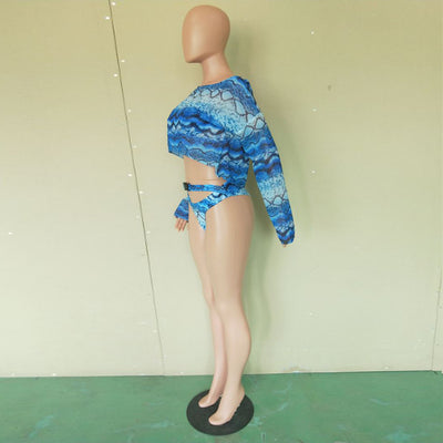 Woman in a purple and pink snakeskin print three-piece swimsuit with an off-shoulder crop top and high-waisted bottoms. - Image 14