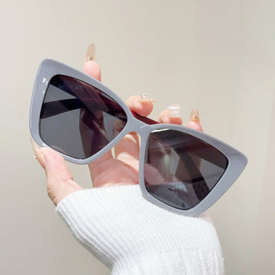 Clear large-frame square glasses held by a hand in a grey knitted sweater, showcasing the transparent plastic frame. - Image 7