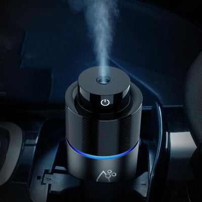 Silver-gray car humidifier and air purifier with a black top, emitting mist and glowing with a blue LED light. - Image 5