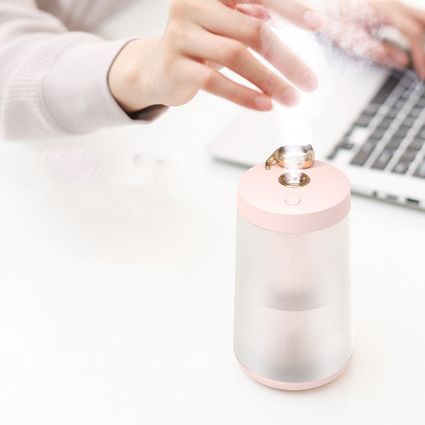 Cute cat-themed USB desktop humidifier with a pink top and base, frosted clear body, and gold cat ear accent.