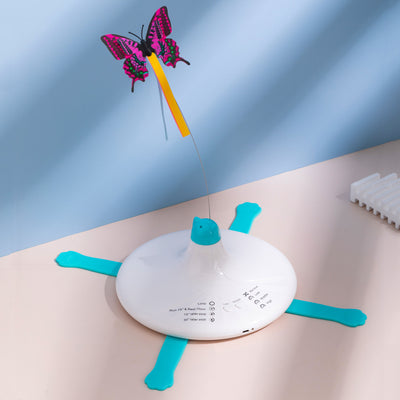 Rechargeable automatic rotating cat toy with a white base, teal paw-shaped feet, and a pink and black butterfly.