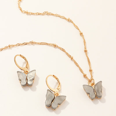 Blue resin butterfly necklace and earring set with gold-tone chains and findings, displayed on a light background. - Image 8