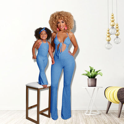 Mother and daughter in matching blue and white striped jumpsuits. Adult wears a halter neck cut-out jumpsuit, child wears a simple halter neck jumpsuit with a m - Image 4