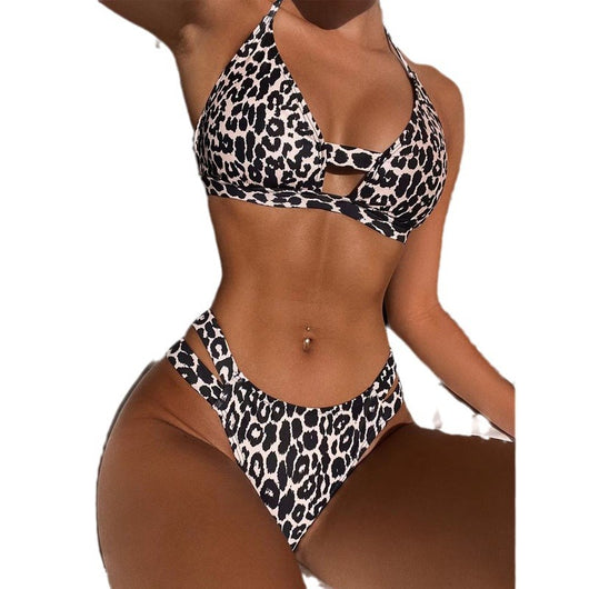 Leopard print high-waisted bikini with a halter neck top and front cutout, worn by a woman lounging outdoors. - Image 5
