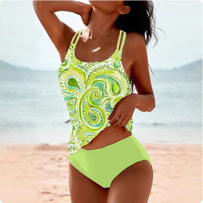 Woman wearing a red retro split high waist tankini swimsuit with an ornate mandala print top on a beach. - Image 14