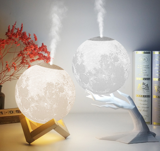 Moon-shaped humidifier and night light with a white deer stand, emitting mist, on a wooden table with books. - Image 7