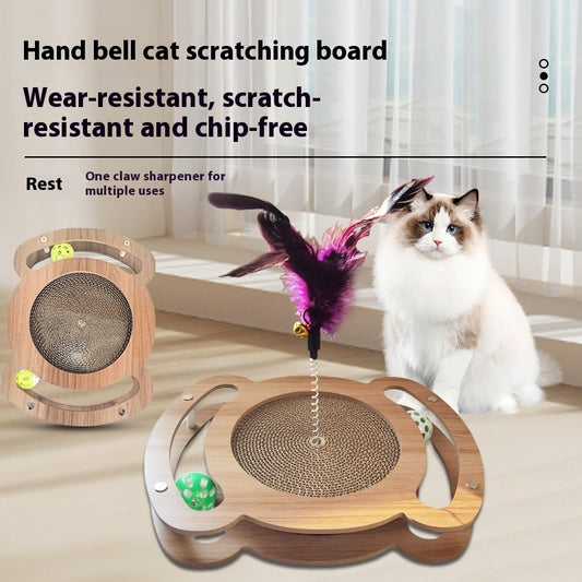 Multi-level cat scratcher with a round corrugated cardboard surface, a wooden track with a green ball, and a pink feather wand with a bell.