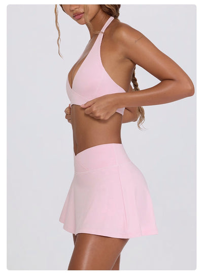 Light pink halter neck sports bra and high-waisted leggings workout set on a model. - Image 38