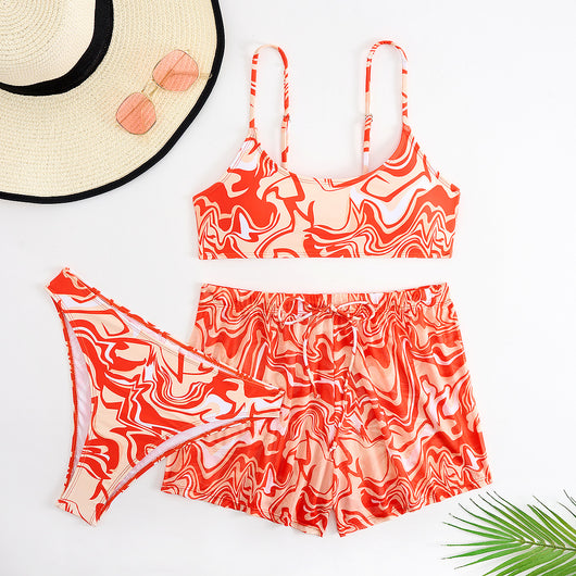 Red, orange, and white abstract swirl print three-piece bikini set with matching shorts, shown with a straw hat and sunglasses. - Image 6