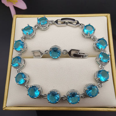 Four-piece silver-tone jewelry set with round green gemstones, including a necklace, bracelet, ring, and dangle earrings. - Image 9