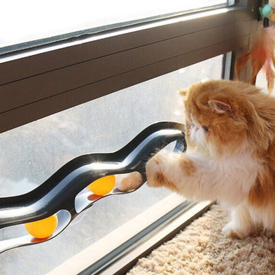 Grey plastic wavy track ball cat toy with two orange balls and suction cups for window or wall mounting. - Image 5