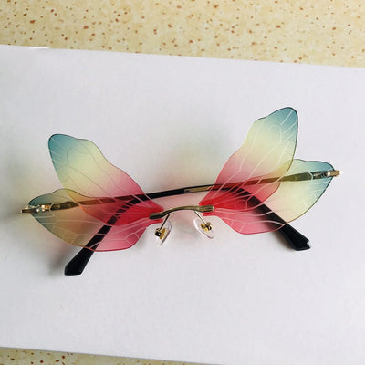 Frameless sunglasses with pink and orange-yellow dragonfly wing-shaped lenses and gold-colored metal temples. - Image 9