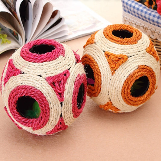 Two sisal cat toys, one pink and natural, one orange and natural, with multiple holes and feathers inside.