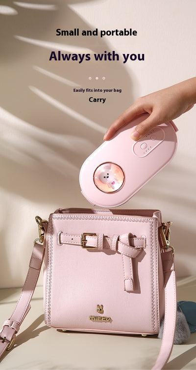 Dark green paw-shaped hand warmer and power bank with a cute bear design, held in a hand with white faux fur gloves. - Image 13