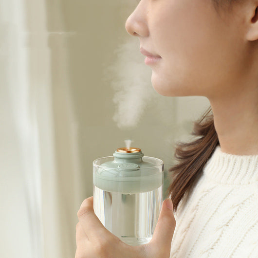 Three 'Drift bottle' humidifiers in white, mint green, and pink, floating in water and emitting mist. - Image 9