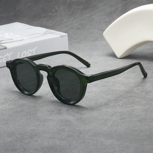 Vintage round frame sunglasses with black frames and pink lenses on a gray surface. - Image 7