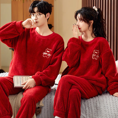 Couple wearing matching cream coral fleece pajamas with gray pants and bear embroidery, seated on a bed. - Image 11