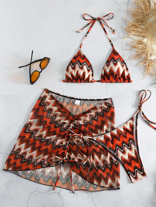Three-piece printed swimsuit with a red and teal abstract pattern, featuring a halter bikini top, bottom, and mesh wrap skirt with drawstring. - Image 4