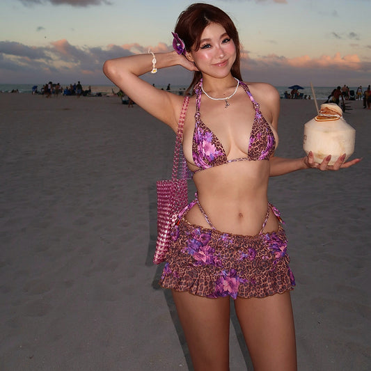 Three-piece bikini set with a brown leopard and pink floral print halter top, matching bottom, and ruched mini skirt.