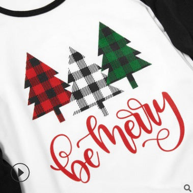 Matching family Christmas pajamas with white tops, black sleeves, buffalo plaid trees, and 'be merry' text. - Image 2