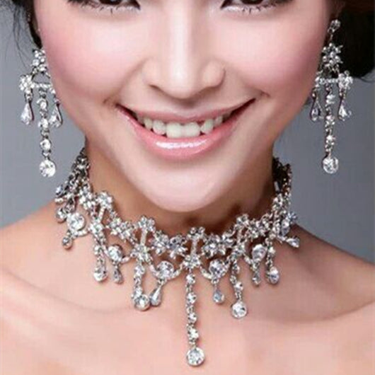 Red and gold bridal jewelry set with a statement necklace and matching dangle earrings, featuring floral and teardrop rhinestones.