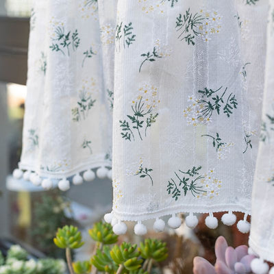 White semi-sheer curtain with green and grey floral pattern and cream tassel trim, hanging in a window. - Image 6