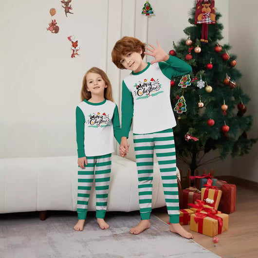 Family of four wearing matching green and white striped Christmas pajamas with "Merry Christmas" graphic. - Image 3