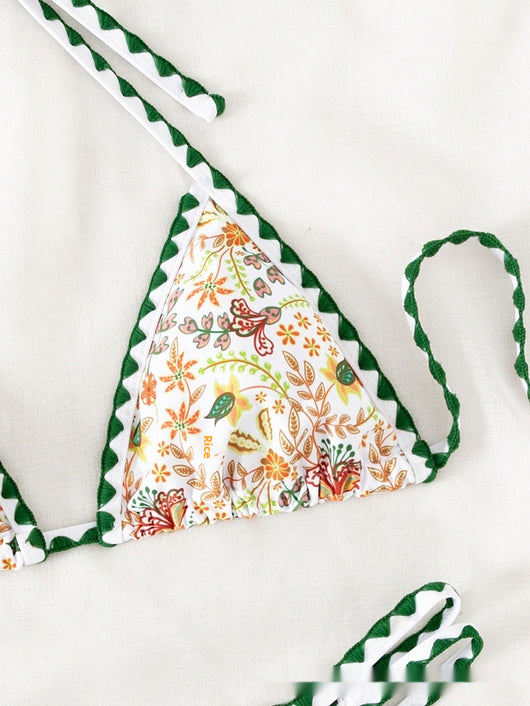 White halter bikini with green rickrack trim and a vibrant floral and bird print, featuring a triangle top and high-cut bottom. - Image 9