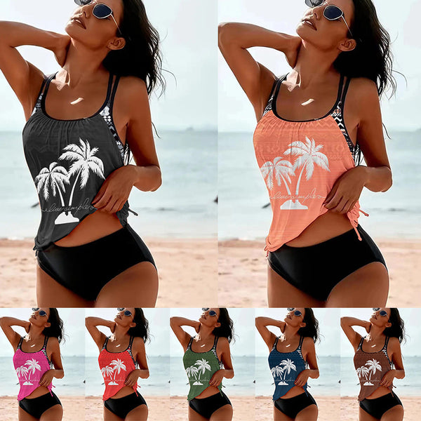 Olive green tankini top with white palm trees and 'live simple' text, paired with black swim bottoms on a beach.