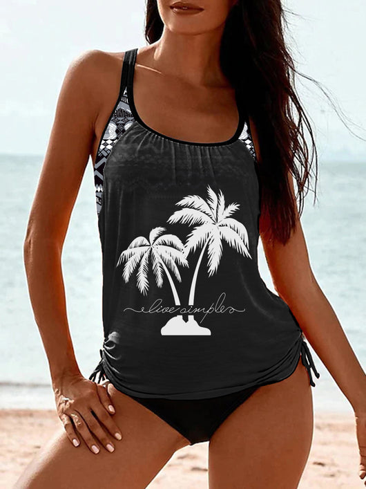 Olive green tankini top with white palm trees and 'live simple' text, paired with black swim bottoms on a beach. - Image 18