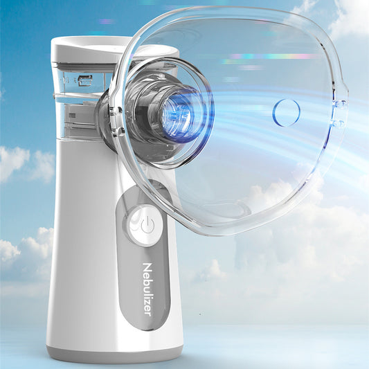 White and blue handheld ultrasonic nebulizer with a clear mask, emitting a blue light, against a bright blue sky.