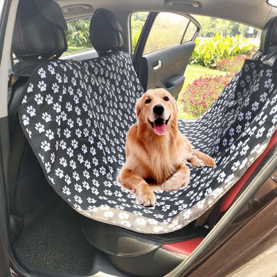 Black Oxford cloth pet car seat cover installed in a car's back seat, forming a hammock to protect upholstery.