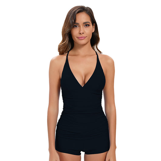 Woman wearing a black two-piece tankini swimsuit with a deep V-neck halter top and ruched sides, paired with boy short bottoms. - Image 9