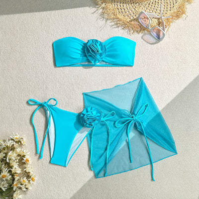 Women's blue tube top swimsuit with a large 3D flower, tie-side bikini bottoms, and a sheer sarong skirt. - Image 7
