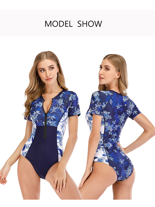 Women's short sleeve surfsuit in blue and white floral and paisley print with solid navy panels and front zipper. - Image 6