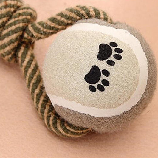 Braided rope dog chew toy with two tennis balls featuring paw prints, shown with a dog holding a similar toy. - Image 7