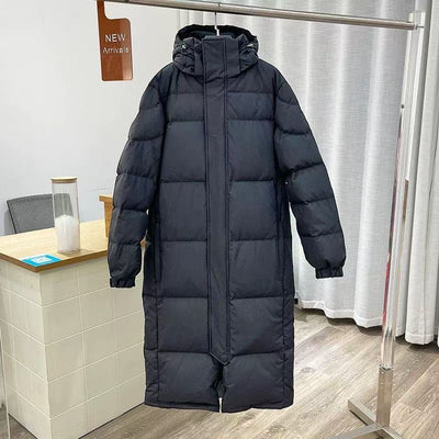 Black mid-length hooded down jacket with a quilted design, hanging on a metal rack in a store. - Image 2