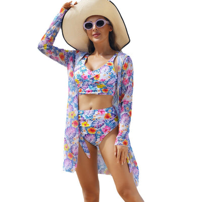 Woman in a red multicolor floral print three-piece swimsuit with high-waisted bikini and long-sleeve cover-up, straw hat, and sunglasses on a beach. - Image 5