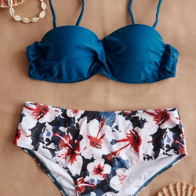 Teal twisted bandeau bikini top with tropical leaf print high-waisted bottoms on a model wearing a white shirt. - Image 3