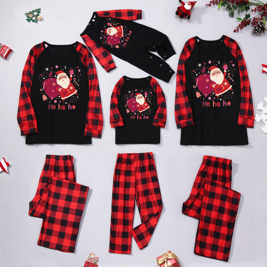Family matching Christmas pajamas with black tops featuring a Santa graphic and red buffalo plaid sleeves and pants. - Image 11