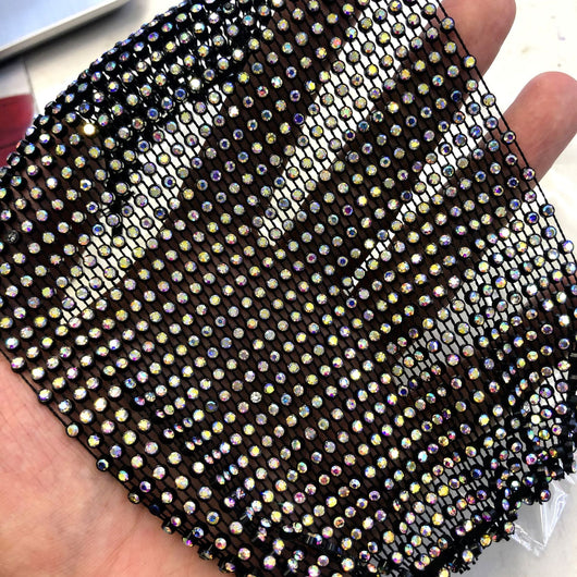 Close-up of a blue mesh fabric adorned with numerous small, clear rhinestones, creating a sparkling texture. - Image 40