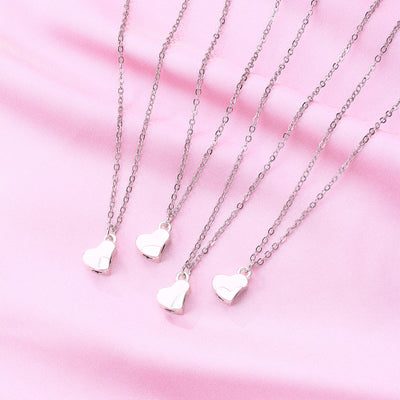 Four silver-colored necklaces, each with a half-heart charm that forms a four-leaf clover when combined, on pink satin. - Image 8