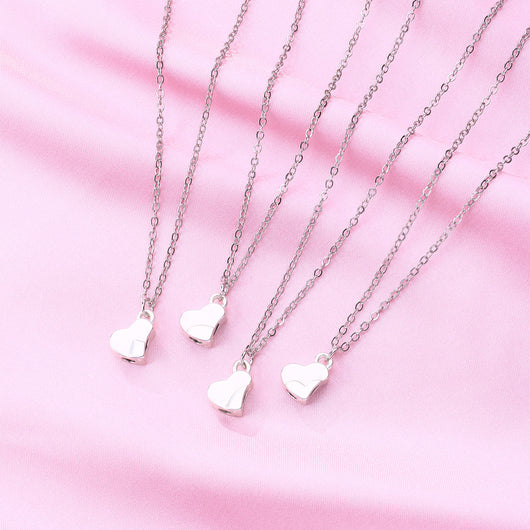 Four silver-colored necklaces, each with a half-heart charm that forms a four-leaf clover when combined, on pink satin. - Image 8