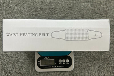 Gray quilted waist heating belt with an adjustable strap, wired remote control, and power plug, shown with its box. - Image 10