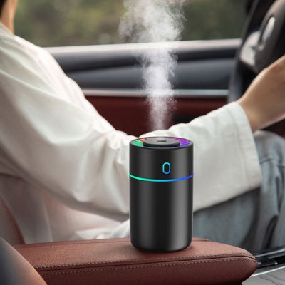 Pink cylindrical humidifier with a colorful LED light ring on top and a blue-green light band around its middle. - Image 9