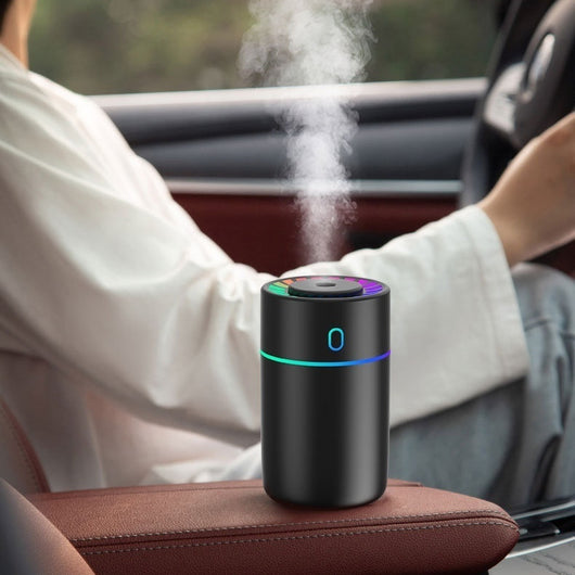 Pink cylindrical humidifier with a colorful LED light ring on top and a blue-green light band around its middle. - Image 9