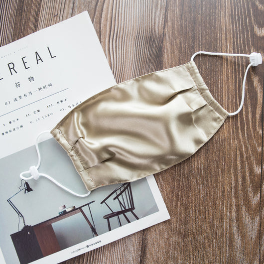 Light pink double layer silk face mask with adjustable white ear loops on an open magazine. - Image 7