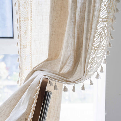 Close-up of a beige semi-transparent curtain with a delicate crochet lace trim and decorative tassels. - Image 4